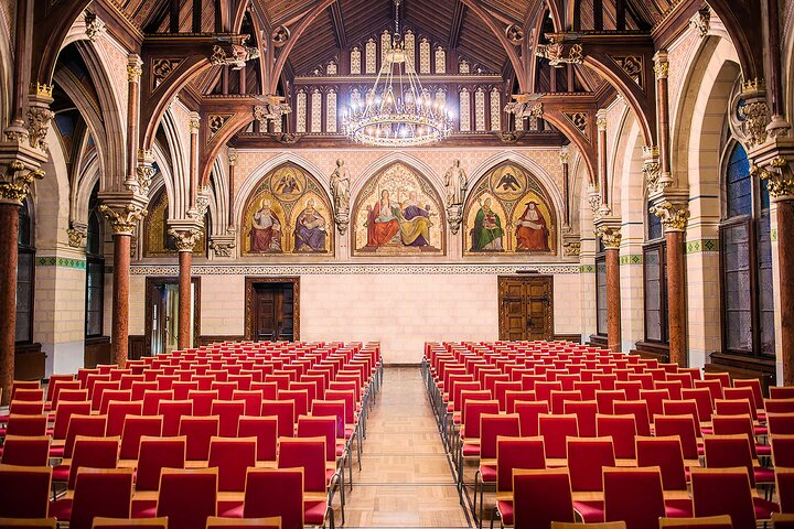 Experience the elegance of a grand concert hall where the rich history of classical music comes alive. Red seats await your presence promising an evening filled with timeless melodies.