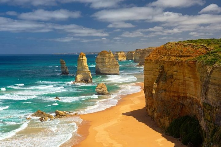 Marvel at the stunning coastline of the Twelve Apostles where towering limestone pillars rise majestically from azure waters offering a breathtaking escape for travelers seeking natural beauty.