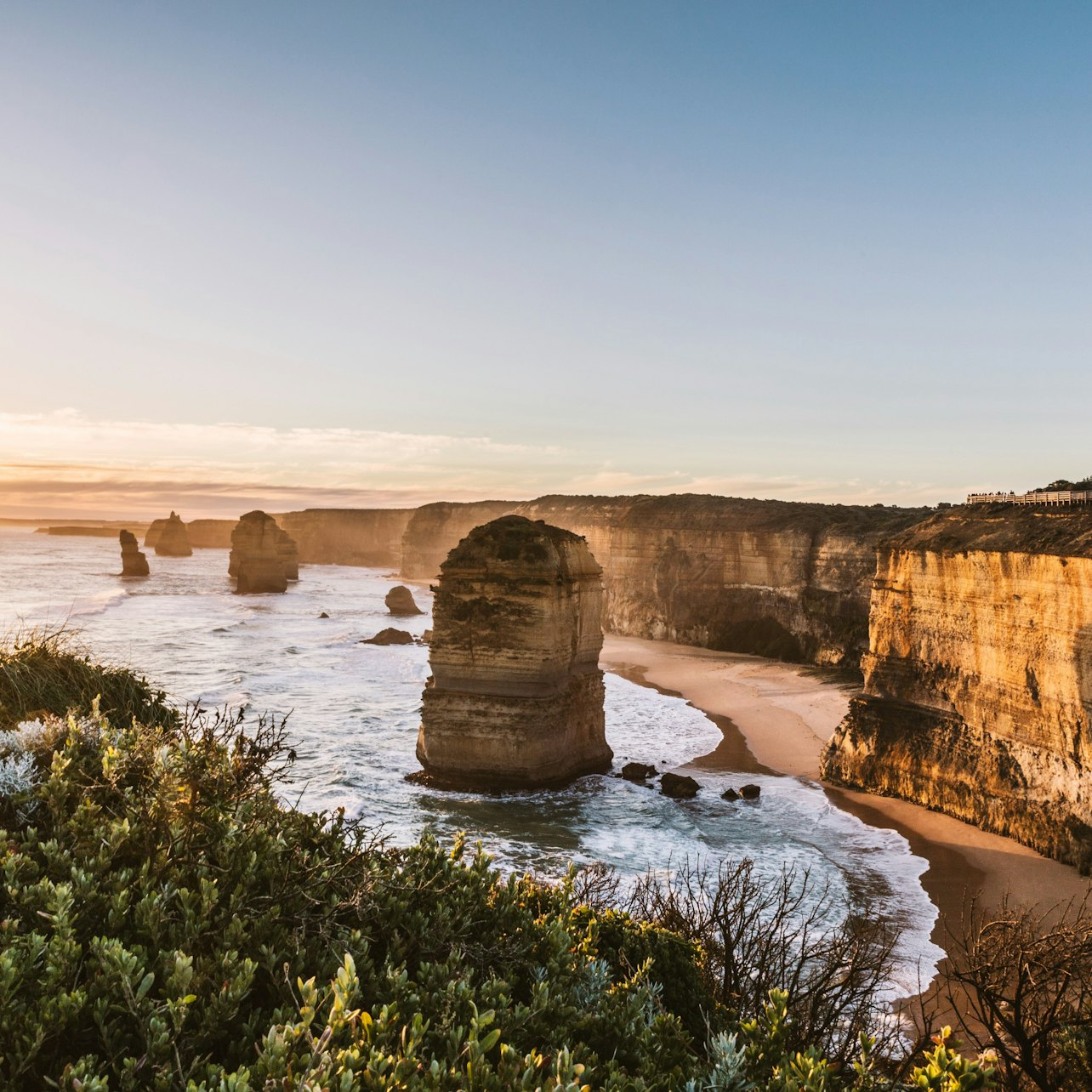 Experience the stunning coastal views of the Great Ocean Road as the sun rises revealing majestic rock formations and the soothing rhythm of waves lapping against the shore.