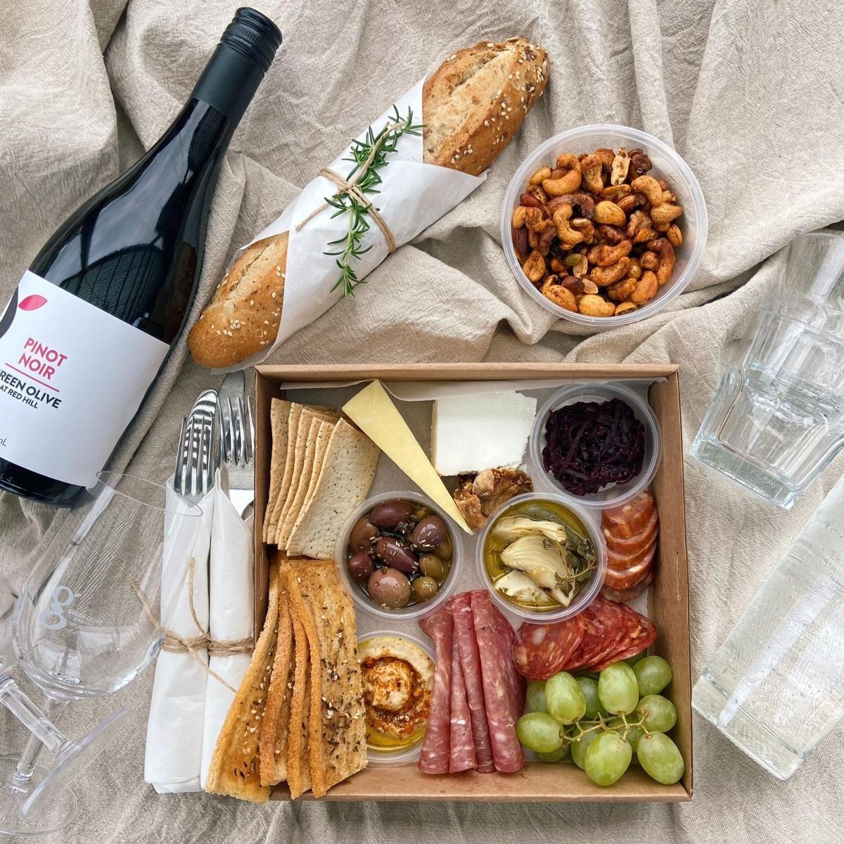 Savor exquisite farm-grown flavors while lounging by serene olive groves accompanied by a delightful grazing platter and fine wine perfect for a romantic escape in Mornington Peninsula.