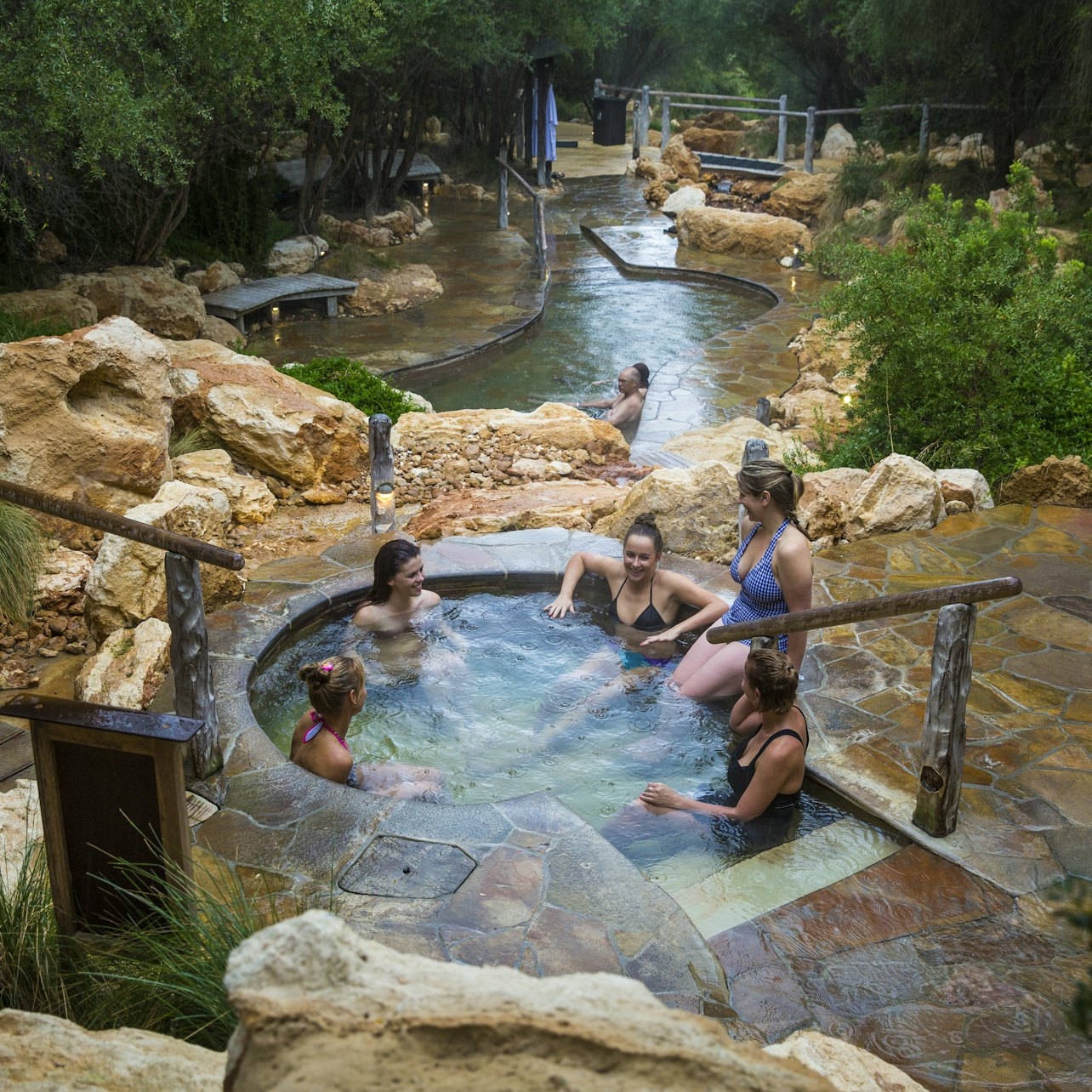 Immerse yourself in the soothing mineral-rich waters of Mornington Peninsula Hot Springs surrounded by nature with friends enjoying a relaxing day and stunning views awaiting just beyond.