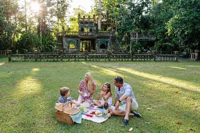 Discover the charm of Paronella Park with a picnic by the falls surrounded by lush rainforest and a stunning castle perfect for creating unforgettable family memories.