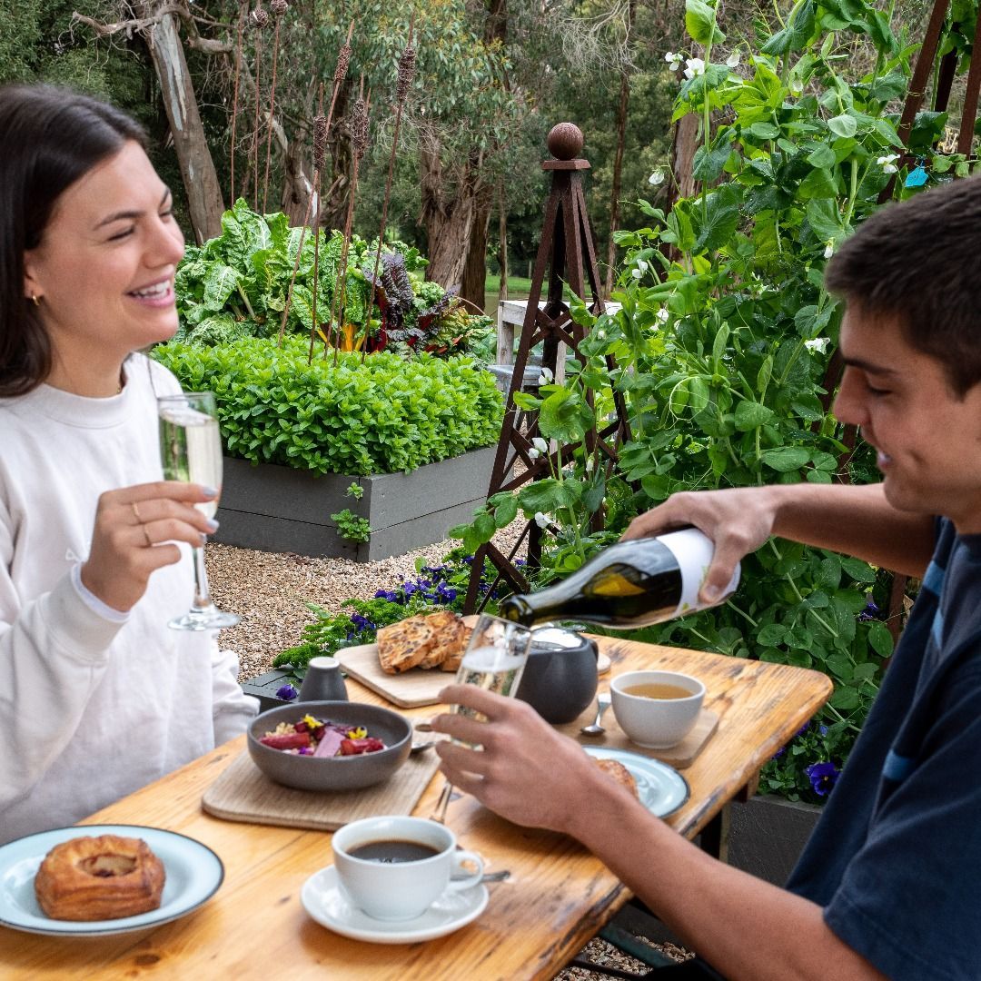 Delight in a serene brunch among lush greenery savoring sparkling wine fresh pastries and warm camaraderie. Perfect for celebrating special moments while immersed in nature's beauty.