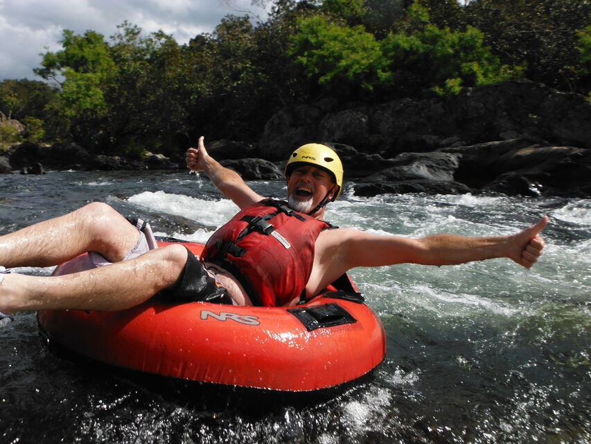 Experience the joy of floating down a serene rainforest river surrounded by lush greenery and playful small rapids ideal for adventurers of all ages in Cairns.