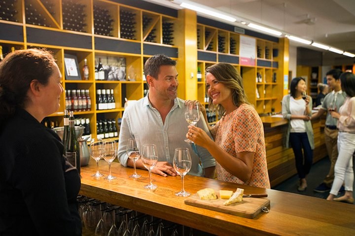 Experience the joy of wine tasting in a welcoming winery setting where friends gather to savor exquisite flavors and share delightful moments over cheese and wine pairings.