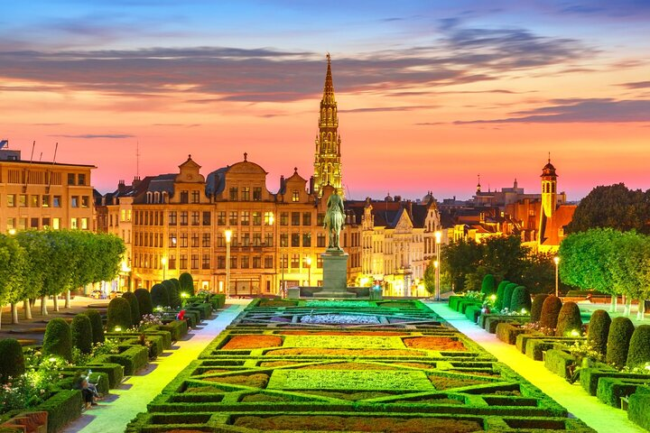 Experience the charm of Brussels as twilight illuminates historic architecture and beautifully arranged gardens perfect for discovering seasonal delights and heartfelt local stories.