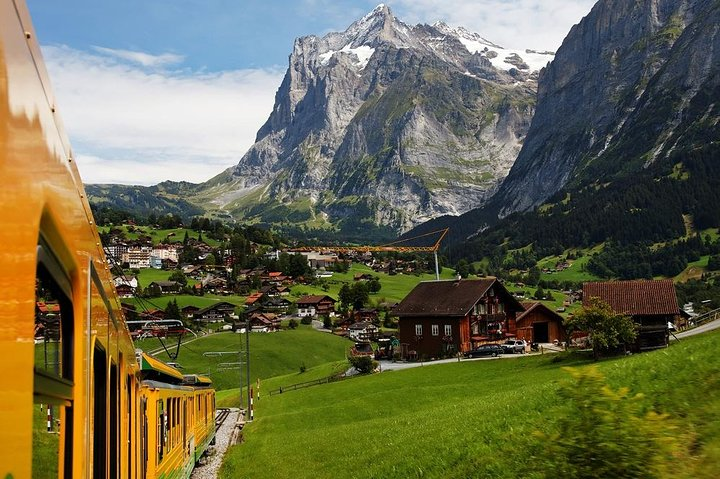 Experience stunning views as you glide through lush alpine meadows with the majestic Eiger mountain range towering in the background. A journey that promises unforgettable landscapes and serene moments.