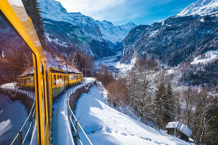 Experience the breathtaking beauty of the Swiss Alps as you glide through stunning landscapes on a private scenic train tour passing charming alpine villages and majestic peaks blanketed in snow.