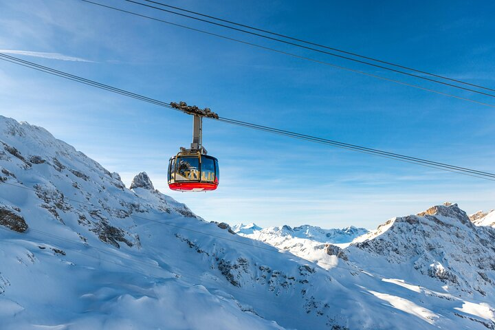 Experience the majesty of Mount Titlis as the cable car glides over stunning snowy peaks offering panoramic views and a chance to embrace alpine adventures in Switzerland's breathtaking landscape.