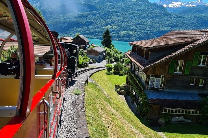 Journey through picturesque landscapes as the steam train winds past charming chalets and shimmering lakes showcasing the untouched beauty of the Swiss Alps for a memorable experience.