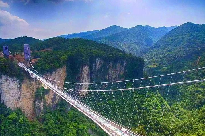 Crossing the world's highest glass bridge offers stunning views of Zhangjiajie National Park's unique landscapes where towering cliffs meet lush greenery creating a perfect adventure for nature lovers.