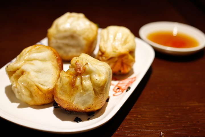 Experience the delightful crunch of freshly made soup dumplings paired with tangy black vinegar a true taste of Shanghai's culinary heritage during your stroll down Huangpi Road.