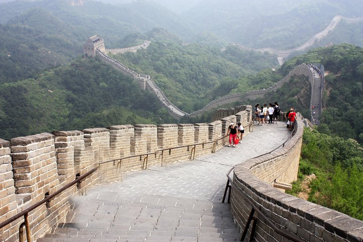 Stand atop the Badaling Great Wall surrounded by sweeping landscapes. Experience a blend of history and nature while sharing moments with fellow travelers. An unforgettable adventure awaits in Beijing.
