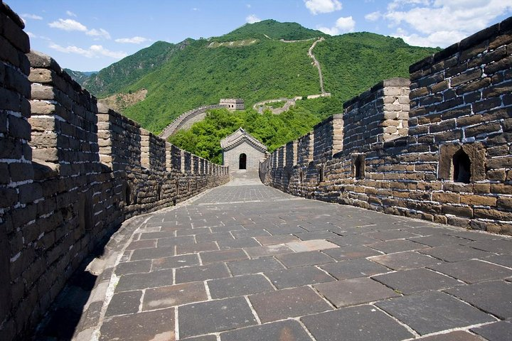 Experience the majestic Mutianyu Great Wall where ancient watchtowers rise above lush landscapes inviting exploration and offering stunning views of the surrounding mountains and valleys.