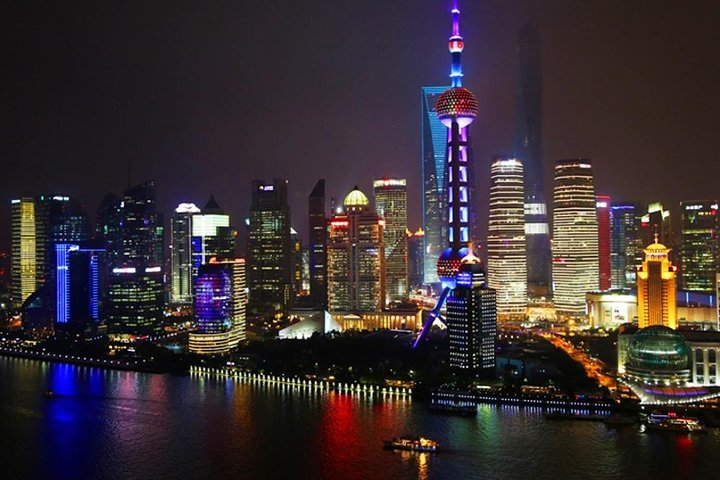 Experience the stunning skyline of Shanghai illuminated at night showcasing the grandeur of the Shanghai Tower and the magical lights reflecting on the Huangpu River. Perfect for night explorers.