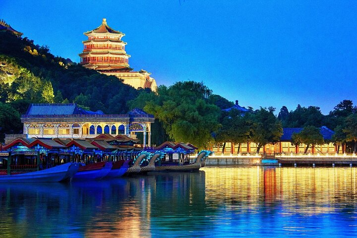 Explore the tranquil beauty of the Summer Palace at night with softly lit gardens and reflections dancing on the water while uncovering ancient stories alongside a knowledgeable guide.