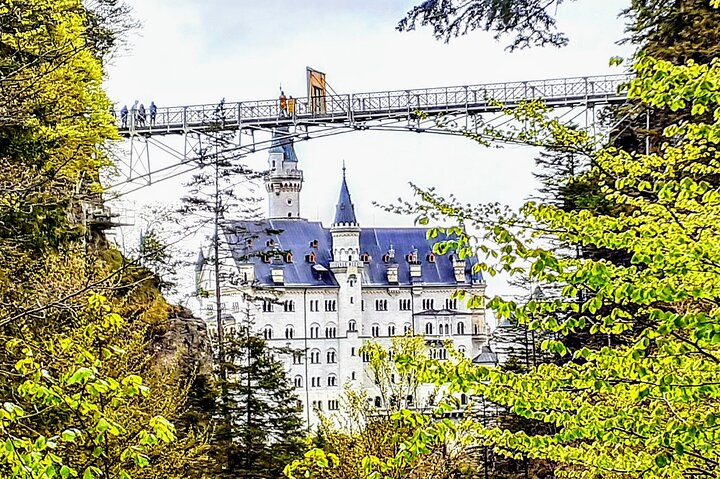Experience breathtaking views as you walk the impressive Highline 179 seamlessly connecting you to the majestic Neuschwanstein Castle surrounded by lush greenery and awe-inspiring architecture.