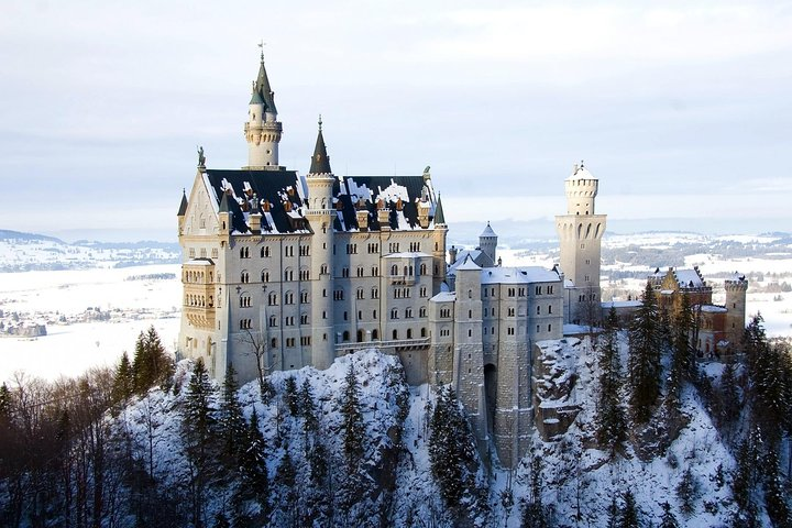 Experience the magic of Neuschwanstein Castle nestled amid the snowy Bavarian Alps offering stunning views guided tours and serene walks along the Alpsee lake perfect for memorable moments.