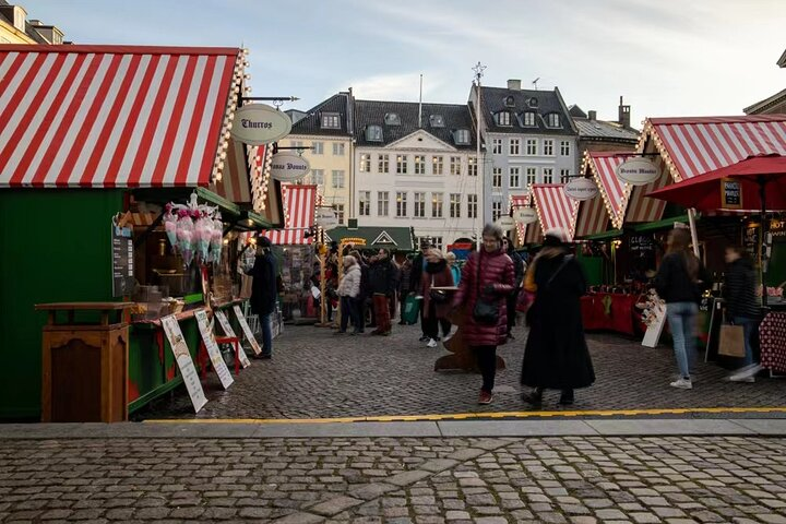Wander through Copenhagen's charming streets with colorful market stalls offering local treats and festive delights inviting you to immerse yourself in the city's joyful Christmas celebration.