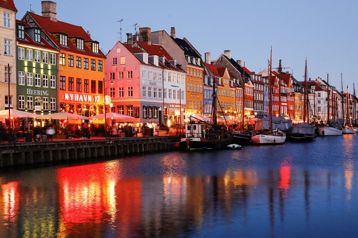 Capture unforgettable moments in Copenhagen's picturesque Nyhavn where colorful facades and reflected lights by the canal create the perfect backdrop for your unique photo story.