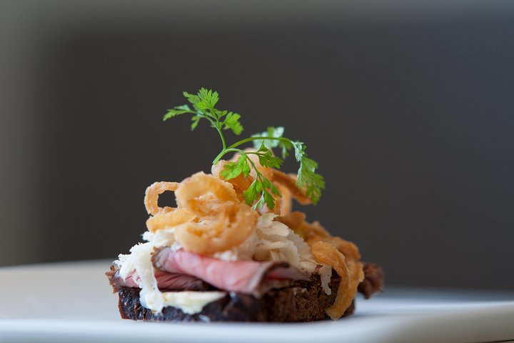 Savor the essence of Copenhagen with an exquisite open rye-bread sandwich topped with fresh ingredients showcasing the best of Nordic flavors in a delightful culinary adventure.