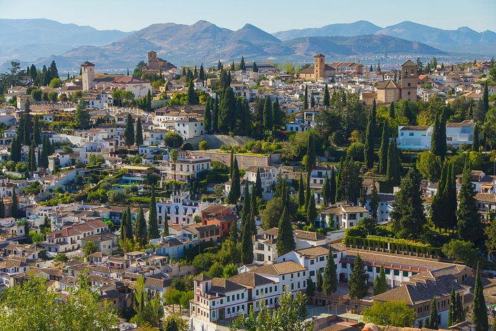 Experience the charm of Andalusian architecture amidst stunning mountain views as you explore the heart of Granada and its iconic Mosque creating unforgettable travel memories.