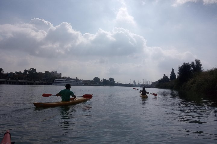 Paddle along the Guadalquivir River soaking in stunning views of iconic landmarks like Torre del Oro and Triana Bridge while enjoying a refreshing outdoor adventure in Seville.