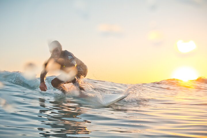 Surf instructor Derek on a perfect wave at sunset