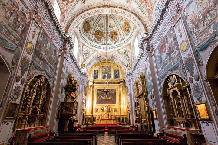 Step inside the stunning baroque interior of Hospital de los Venerables where magnificent frescoes and intricate ceramics create a breathtaking backdrop for exploring Seville's rich artistic heritage.