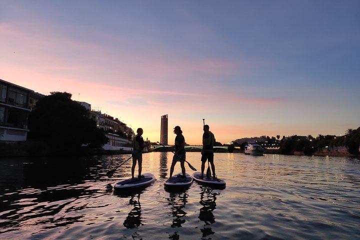 Experience the magic of Seville as you paddle board at sunset gliding over shimmering waters while the city’s stunning skyline unfolds before you creating unforgettable memories.