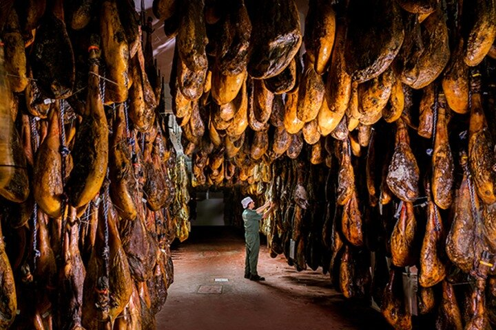 Explore the unique process of Iberian ham production surrounded by hanging delicacies and delve into Spain's culinary traditions in this fascinating drying room experience.