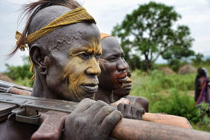 A group of Mursi tribe man's with traditional face painting in lower omo valley.