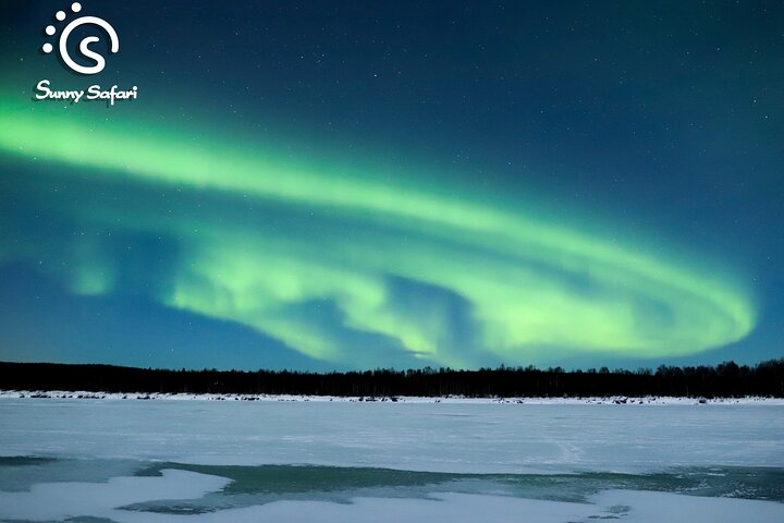 Witness the mesmerizing dance of the Northern Lights above Rovaniemi's frozen lakes where nature's artistry creates unforgettable moments amid Lappish serenity and warmth by the campfire.