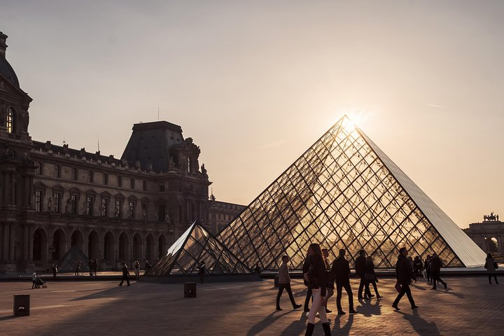 As the sun sets behind the Louvre's iconic pyramid wander through a quieter museum appreciating the Mona Lisa and other masterpieces in a serene moment of artistic reflection.