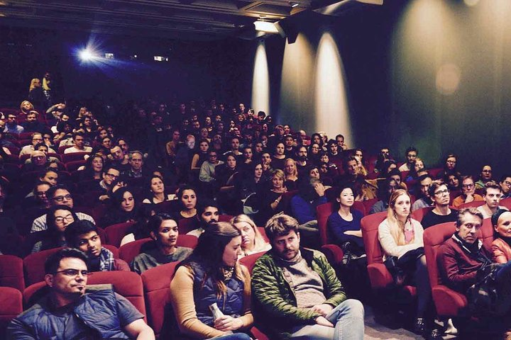 Immerse yourself in the cinematic charm of Paris enjoying French films with English subtitles while surrounded by fellow film enthusiasts in a cozy screening room.