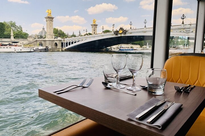 Experience the Seine as you savor a delightful dinner aboard the IVOIRE with stunning views of the iconic Pont Alexandre III enhancing your memorable evening on the water.
