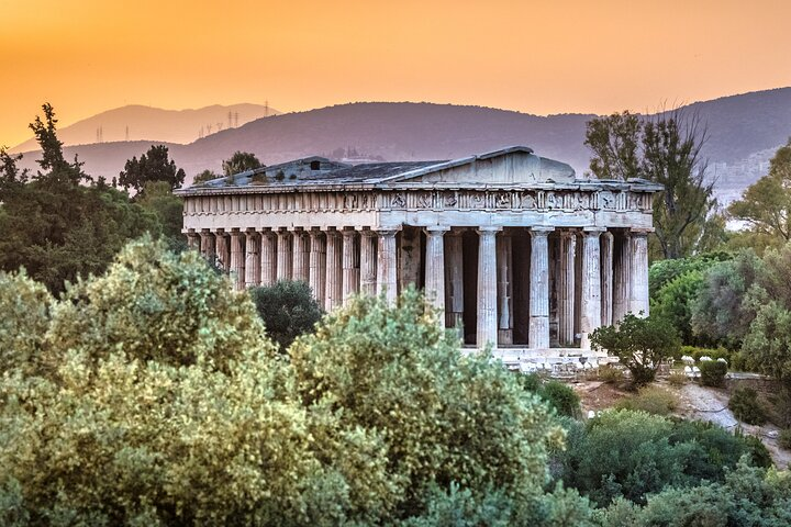 Experience the essence of ancient Greece as you stroll among the ruins of the Agora taking in the rich history and stunning architecture under the glow of a sunset.