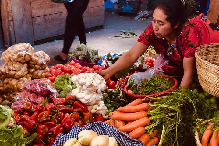 Market vendor arranging vegetables in the market in Antigua Guatemala