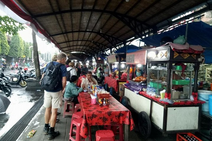 Experience the lively energy of Bali's night market where locals savor traditional dishes like Babi Guling and Ayam Tutu surrounded by colorful stalls and the aroma of street food delights.