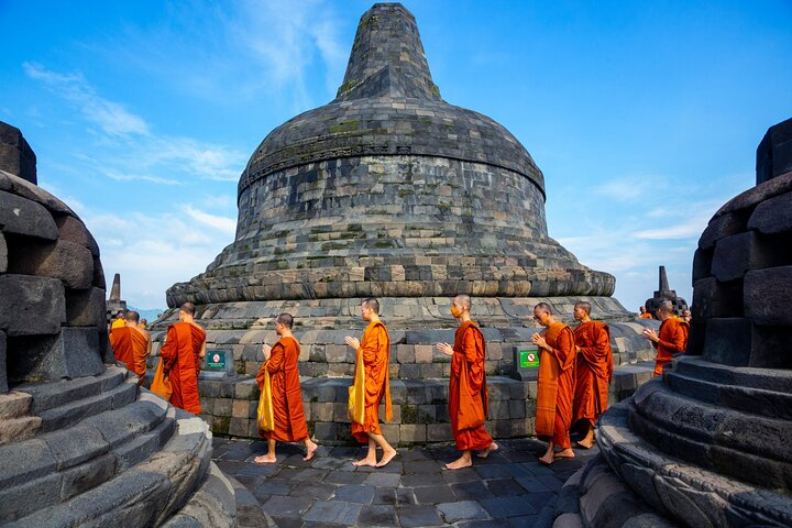 Explore the stunning architecture of Borobudur Temple where history mingles with spirituality. Witness the serene moments as monks walk adding to the temple's charm and cultural significance.