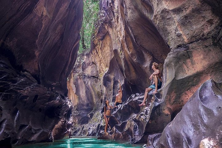 Discover the stunning beauty of Beji Guwang's canyon where lush greenery meets impressive rock formations and crystal-clear waters invite adventure and exploration in Bali's hidden gem.