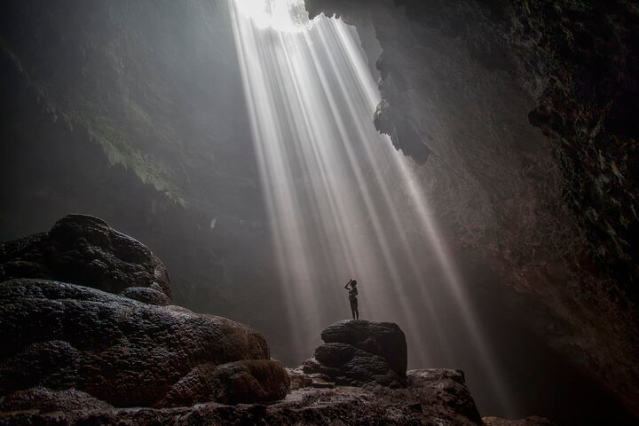 Discover the breathtaking beauty of Jomblang Cave where sunlight streams through the dramatic opening creating an unforgettable experience amid nature's wonders. Adventure awaits at every turn!