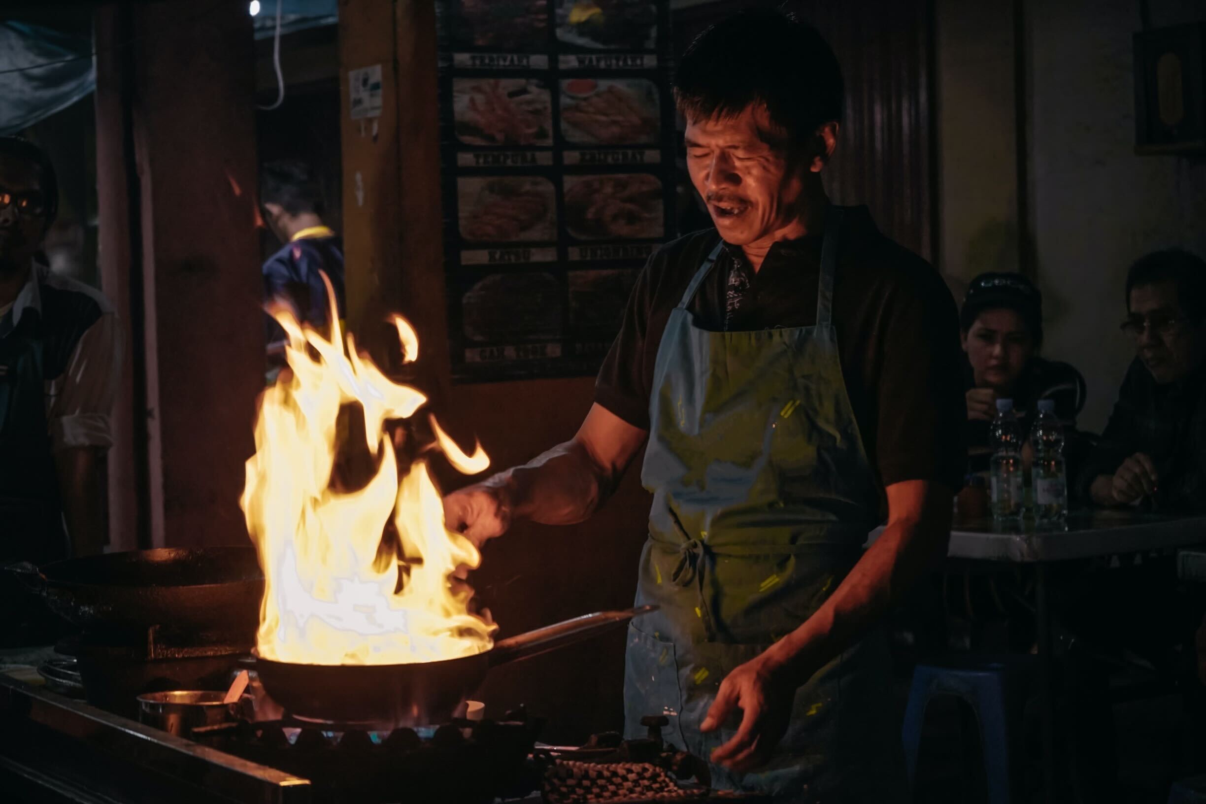 Experience the culinary magic of Yogyakarta as skilled chefs ignite flavors showcasing local cuisine amid the nighttime charm of bustling street life and savory delights.