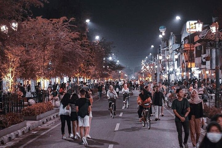 Experience the lively energy of Yogyakarta at night where street food stalls bustling crowds and charming rickshaw rides create memorable moments filled with local culture and delicious flavors.