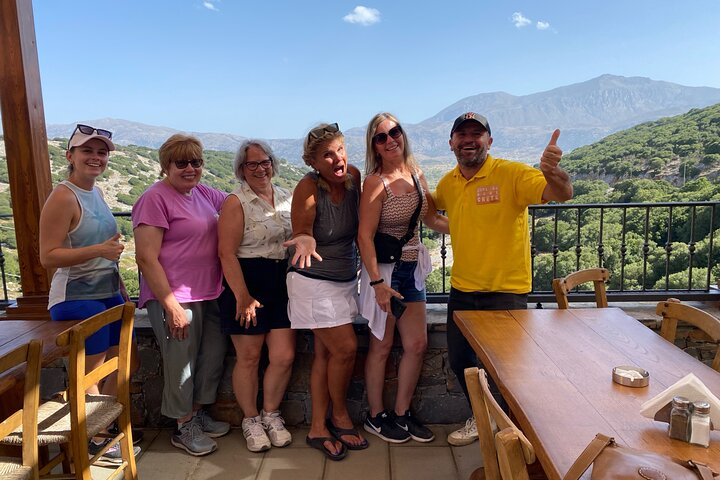 Experience the charm of Crete with stunning mountain views and shared moments at a local eatery perfect for enjoying traditional cuisine and connecting with fellow travelers.