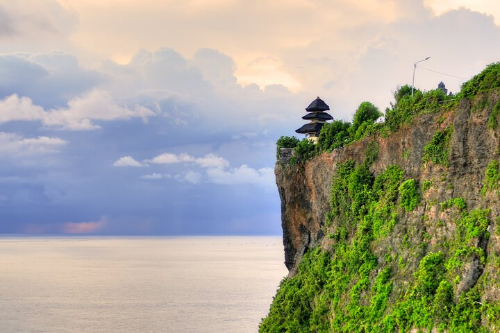 Discover stunning coastal views from Uluwatu Temple as the sun sets perfectly framing an unforgettable evening filled with the mesmerizing Kecak Fire Dance experience.