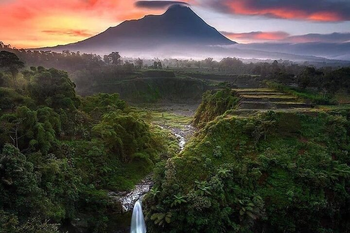 Experience lush rice terraces and a hidden waterfall all set against majestic mountains in Yogyakarta. Explore nature and connect with local culture on this unforgettable journey.