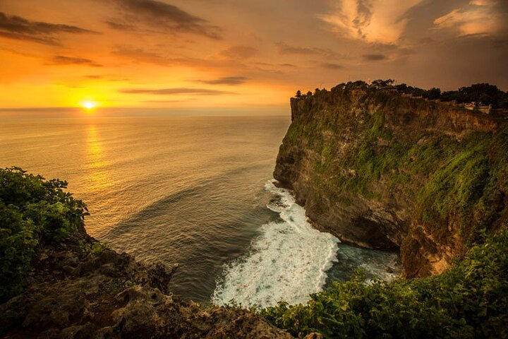 Experience the stunning views of the Indian Ocean as the sun sets over Uluwatu Temple while enjoying traditional Kecak Dance and a delightful seafood dinner on Jimbaran Beach.
