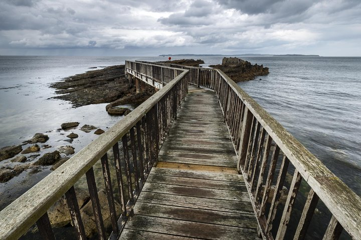 Explore the rugged beauty of Ireland's coastline as you stroll along this picturesque wooden pier a perfect spot to reflect on your Game of Thrones adventure.