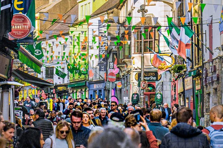 Experience the colorful charm of Galway City where lively streets are filled with locals and visitors celebrating Irish culture amid historic buildings and bustling shops. Discover the heart of this vibrant city.